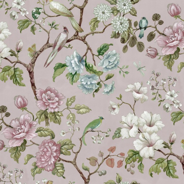 Tapet floral Grandiflora, roz pal, cu flori roz și albe, păsări și frunze verzi, decorând un living cu o canapea alba și un fotoliu verde.
