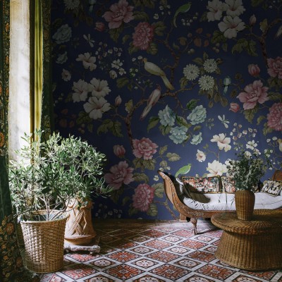 Tapet floral Grandiflora Blue, cu flori mari, roz si albe, pe fond albastru inchis. Designul include si pasari si frunze.
