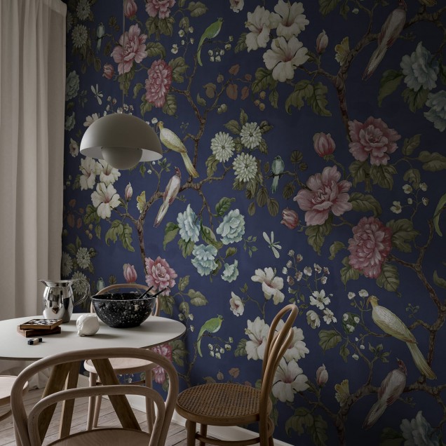 Tapet floral Grandiflora Blue, cu flori mari, roz si albe, pe fond albastru inchis. Designul include si pasari si frunze.