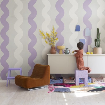 Tapet cu design ondulat Wobbly Lilac, cu nuanțe de liliac și alb, într-un living cu mobilier modern.