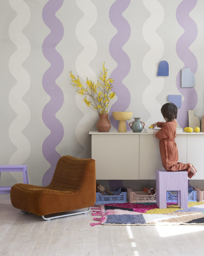 Tapet cu design ondulat Wobbly Lilac, cu nuanțe de liliac și alb, într-un living cu mobilier modern.