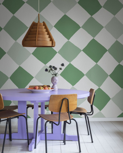 Tapet Tremble Green, model geometric cu pătrate, nuanțe de verde și alb, aplicat pe un perete din sufragerie, lângă o masă cu scaune.