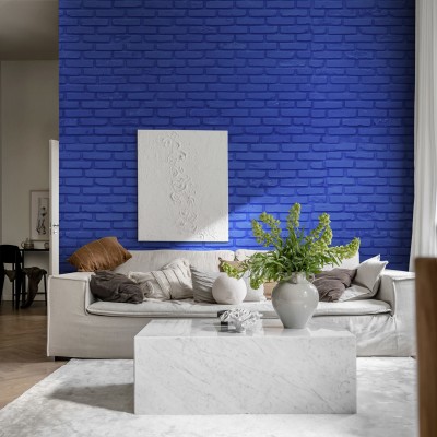 Wallpaper cu aspect de cărămidă, în nuanța cobalt, în decorul unei camere cu canapea albă și o masă de cafea din marmură.