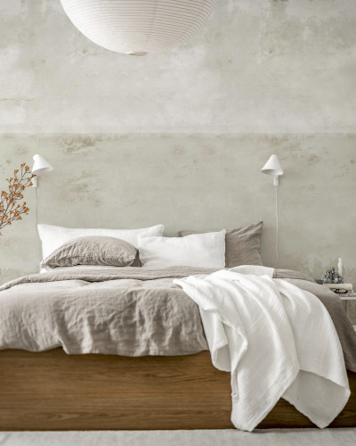 Tapet Urban Horizon Sand, cu aspect de beton texturat, aplicat pe un perete din dormitor