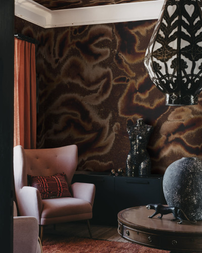 Tapet Guppy, maro, cu design abstract,  ilustrat pe un perete din living, cu o canapea roz, o masă de cafea și o lampă.