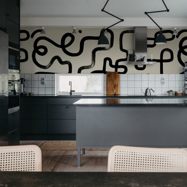 Tapet abstract cu linii negre groase pe un fundal bej deschis, aplicat pe un perete din living