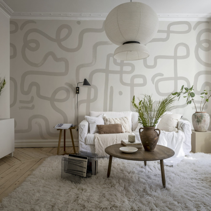 Tapet cu design abstract in nuante de alb si gri, cu linii delicate, aplicat intr-un living modern.
