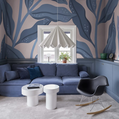 Tapet Cool Flora, Pink & Blue, cu frunze mari, albastre, pe un fundal roz pal, în living.