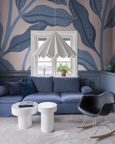 Tapet Cool Flora, Pink & Blue, cu frunze mari, albastre, pe un fundal roz pal, în living.