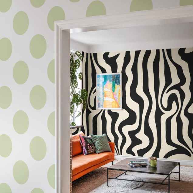 Tapet cu puncte mari, de un verde deschis, decorând un living modern cu canapea și o plantă.
