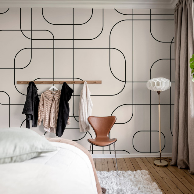 Wallpaper cu linii grafice negre pe fundal bej, in interiorul unei camere de zi moderne.