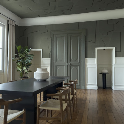 Tapet abstract verde, cu design modern, in interiorul unei camere de zi, cu o masa si scaune