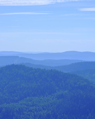 Tapet Hills, Blue cu o vedere spre munți. Tapetul este amplasat într-o cameră de dining, cu o masă albă acoperită cu o fața de masă albă și scaune negre.
