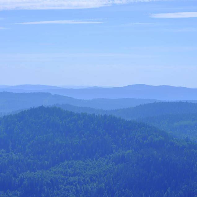 Tapet Hills, Blue cu o vedere spre munți. Tapetul este amplasat într-o cameră de dining, cu o masă albă acoperită cu o fața de masă albă și scaune negre.