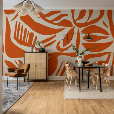 Tapet abstract cu frunze in nuante de terracotta, aplicat pe un perete in living,  arată o masă de dining, scaune, un dulap și o canapea