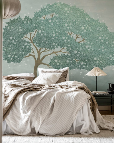 Tapetul Windy Tree, Blue prezinta un copac cu frunze verzi si flori albe delicate, pe un fundal albastru deschis.