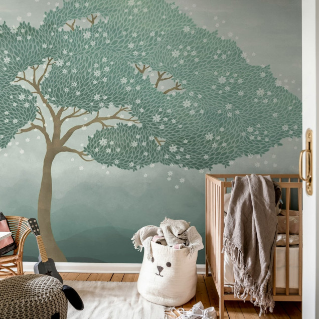 Tapetul Windy Tree, Blue prezinta un copac cu frunze verzi si flori albe delicate, pe un fundal albastru deschis.