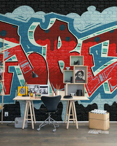 Tapet Rebel Graffiti, Red, cu un design urban in rosu, albastru si verde. Tapetul este pozitionat pe un perete din camera de zi, alaturi de o masa de lucru.