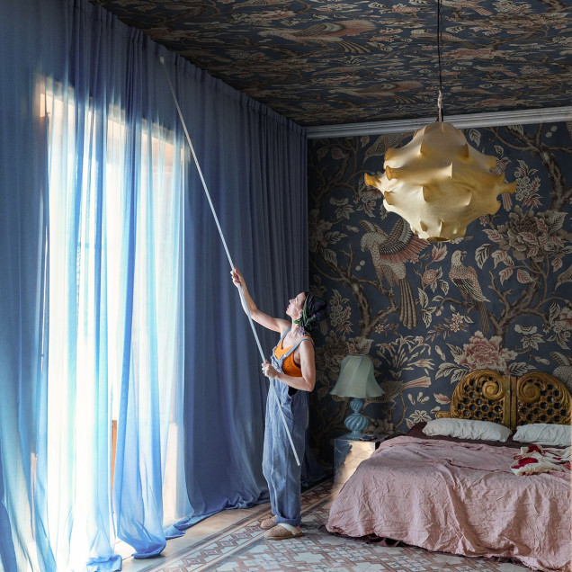 Tapet floral cu păsări stilizate pe fundal bleumarin într-un living elegant.
