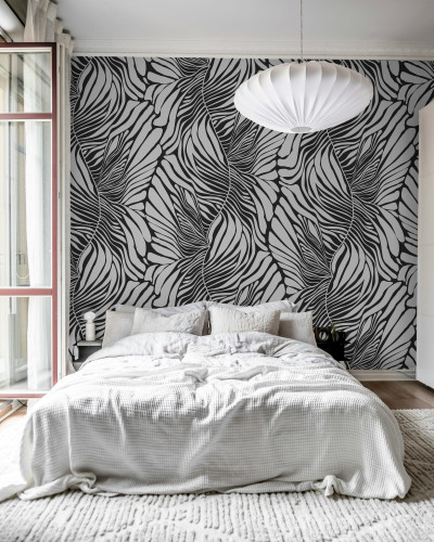 Tapet abstract Seagrass, Graphite, cu model de frunze curbate in tonuri de gri, in interiorul unui dormitor modern.