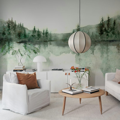 Imagine cu tapet watercolor cu design de pădure verde. Tapetul este lipit pe peretele unei camere amenajate în stil modern, cu canapea albă, fotolii albe și o masă de cafea din lemn.