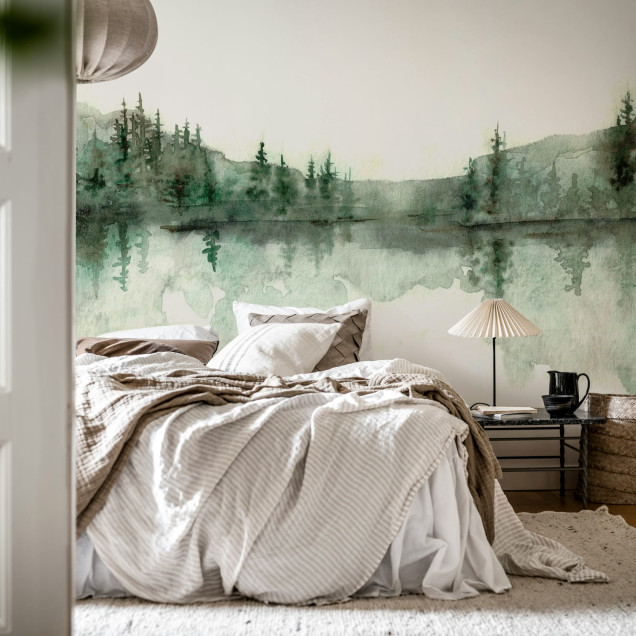 Imagine cu tapet watercolor cu design de pădure verde. Tapetul este lipit pe peretele unei camere amenajate în stil modern, cu canapea albă, fotolii albe și o masă de cafea din lemn.