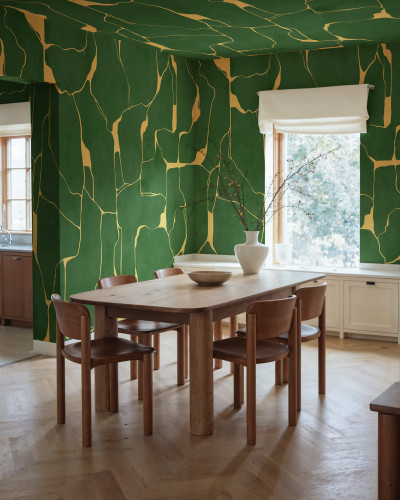 Tapet cu linii aurii pe fundal verde într-o sufragerie elegantă