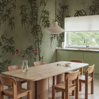 Tapet verde cu motiv bambus într-o cameră cu mobilier din lemn.