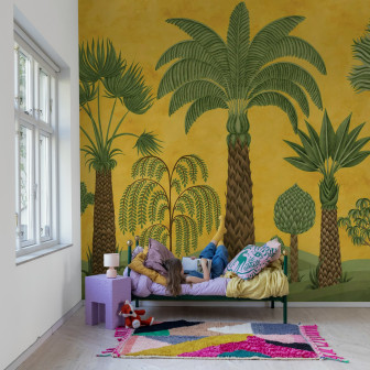 Tapet cu design botanic galben și verde într-o cameră cu o fată citind pe pat