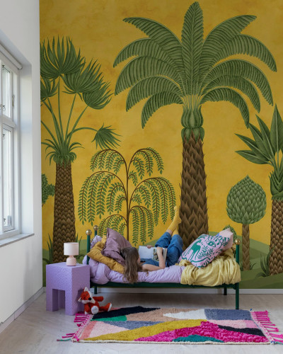 Tapet cu design botanic galben și verde într-o cameră cu o fată citind pe pat
