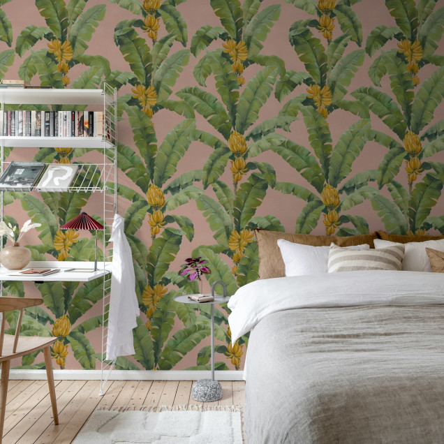 Tapet cu frunze de bananier pe fundal roz într-o cameră de zi luminoasă