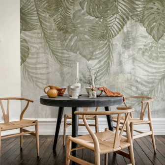 Fototapet Monstera Wall Green cu frunze tropicale verzi pe fundal texturat, într-un interior modern cu zona de luat masa.