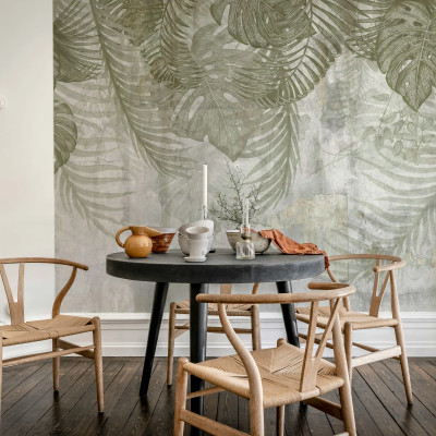 Fototapet Monstera Wall Green cu frunze tropicale verzi pe fundal texturat, într-un interior modern cu zona de luat masa.