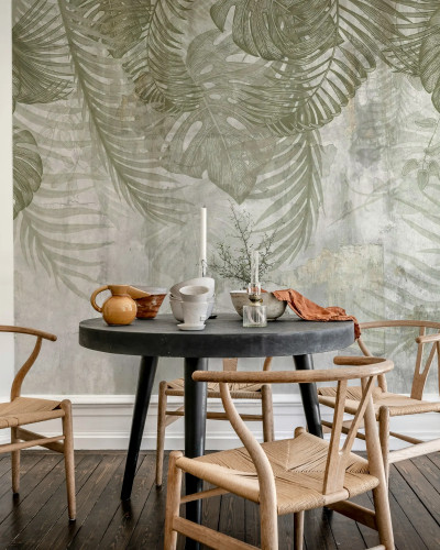 Fototapet Monstera Wall Green cu frunze tropicale verzi pe fundal texturat, într-un interior modern cu zona de luat masa.