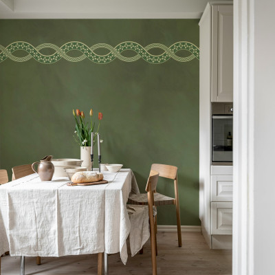 Tapet elegant cu motiv floral verde pe un perete verde
