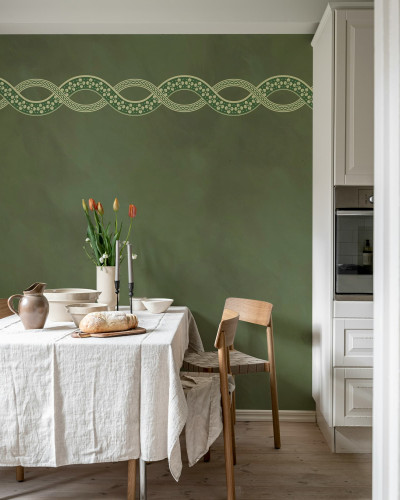 Tapet elegant cu motiv floral verde pe un perete verde