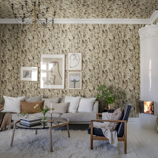 Tapet No Time to Waste Sand cu frunze elegante în tonuri calde de nisip, în decorul unui dormitor rustic.