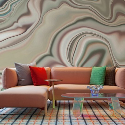 Tapet cu design abstract din marmură în culori neutre, decorând un living cu canapea roz și o masă de cafea.