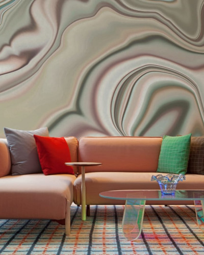 Tapet cu design abstract din marmură în culori neutre, decorând un living cu canapea roz și o masă de cafea.