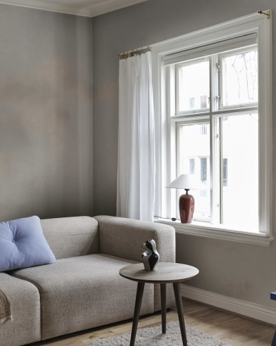 Tapet lavabil cu design minimalist in nuante delicate de albastru si gri, aplicat pe un perete intr-un living modern.