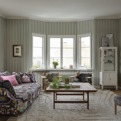 Tapet cu dungi verticale subtile, în nuanțe de verde și alb, decorat cu mobilier modern.
