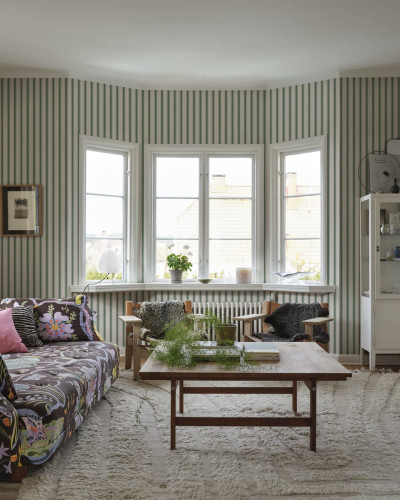 Tapet cu dungi verticale subtile, în nuanțe de verde și alb, decorat cu mobilier modern.