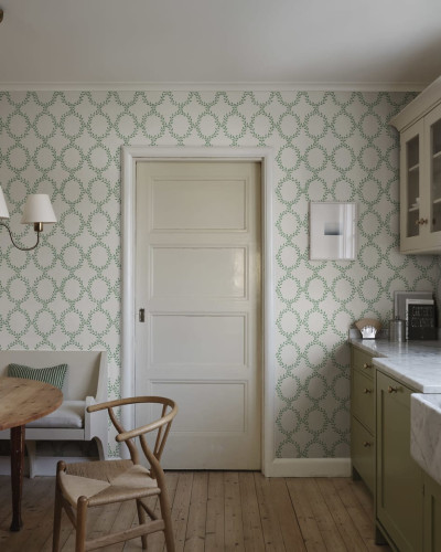 Tapet lavabil Wilma Green, cu un design modern, care prezintă un model rafinat de frunze verzi pe un fundal crem.
