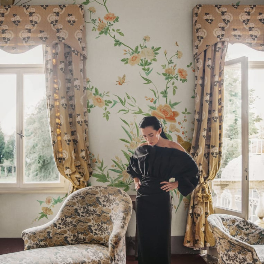 Tapet cu design floral elegant, cu motive florale delicate și păsări, pe un fundal albastru închis.