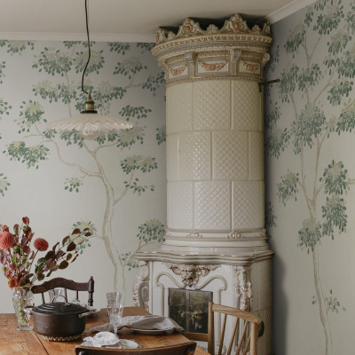 Tapet cu design floral verde într-o cameră cu sobă