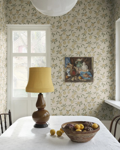 Tapet Limone Yellow cu model de lămâi galbene pe fundal crem, într-o cameră de dining luminoasă cu mobilier clasic și accesorii mediteraneene.