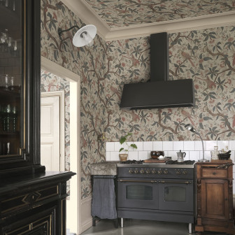 Tapet Alexa, Misty Blue cu model de păsări și ramuri florale, aplicat pe pereții și tavanul unei bucătării amenajate în stil clasic-vintage cu mobilier închis la culoare și aragaz negru.