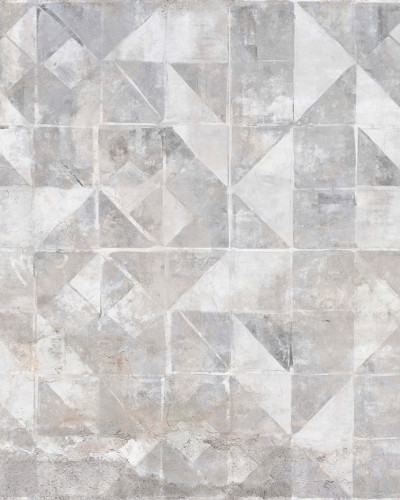 Tapet modern cu model geometric Tintagel, Grey, ilustrat pe un perete din living, lângă un fotoliu gri cu perne decorative.