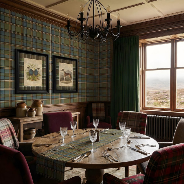 Living decorat cu tapet tartan albastru si verde, semineu, biblioteca si canapea de piele