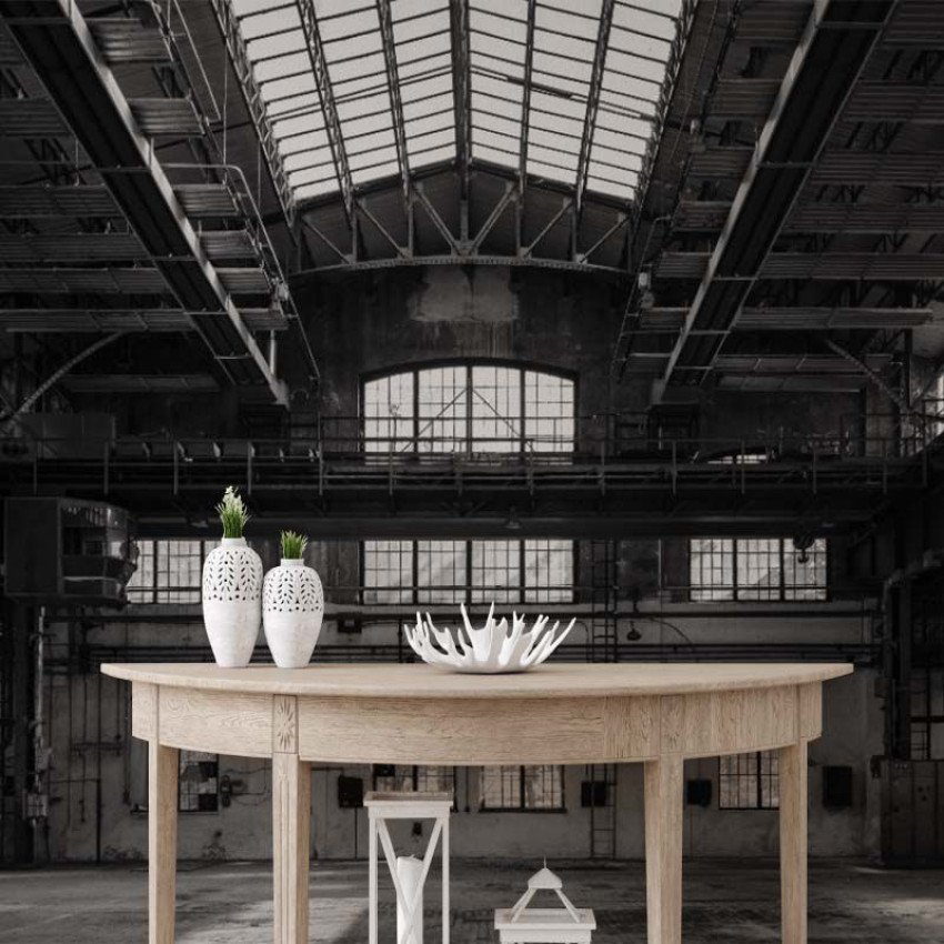 Tapet Industrial Grey, cu un design modern, inspirat de spațiile industriale. Acesta prezintă o imagine a unui hală cu o structură metalică și ferestre mari, în nuanțe de gri.